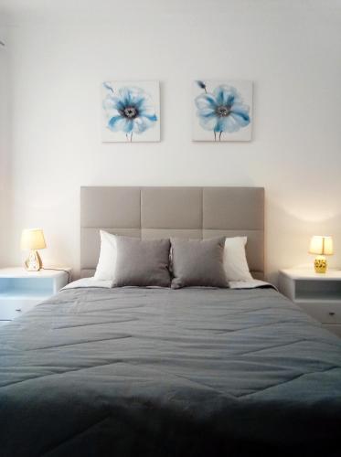 a bedroom with a large bed with blue flowers on the wall at Chalas place in Nazaré