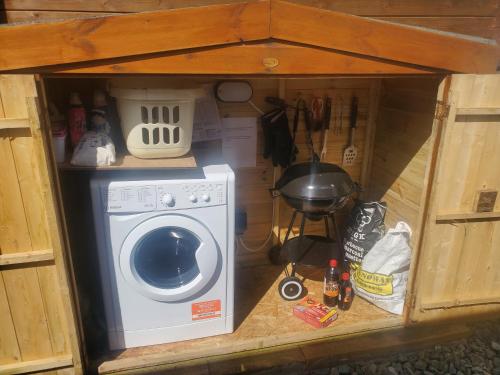 a small house with a washing machine in it at Harlosh Log Cabins in Dunvegan