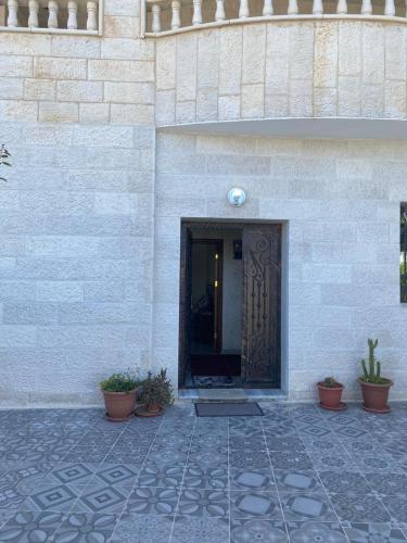 a door to a building with potted plants in front of it at Jerash air apartment in Jerash