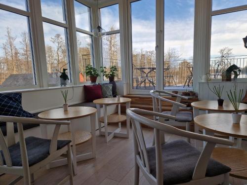 a restaurant with tables and chairs and large windows at Toftastrand Hotell in Växjö