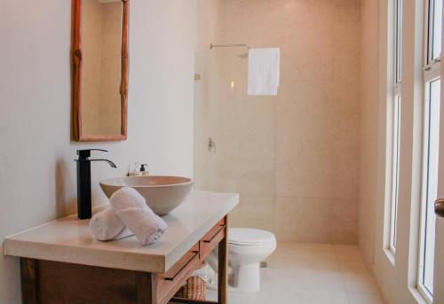 a bathroom with a sink and a toilet at AGAM Hotel Boutique Bacalar - Adults Only in Bacalar