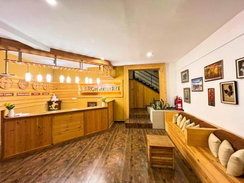 a kitchen with wooden floors and a bar with a bench at 3 Arch Resort Ella in Ella