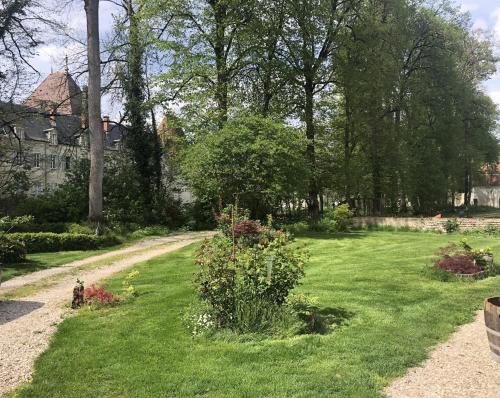a garden with green grass and flowers and a house at La Ferme du Château in Beire-le-Châtel