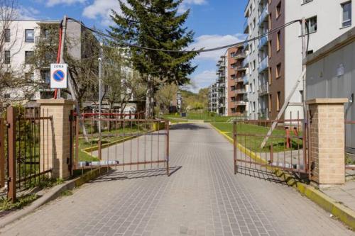 an empty street with a gate and some buildings at Žvėryno appartment-Self check-in-Free garage in Vilnius