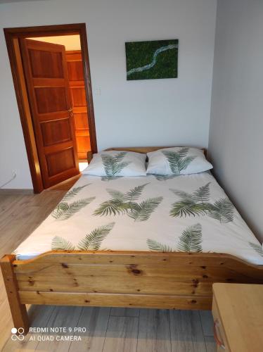 a bedroom with a bed with a wooden bed frame at Zielona Dolina in Rutka Tartak