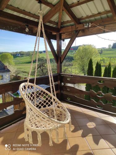 a swinging chair on a porch with a view at Zielona Dolina in Rutka Tartak