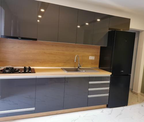a kitchen with a sink and a black refrigerator at Petőfi Apartment in Miercurea-Ciuc