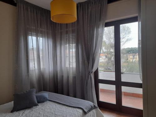 1 dormitorio con cama y ventana grande en Appartamento Le Rose, en Viareggio