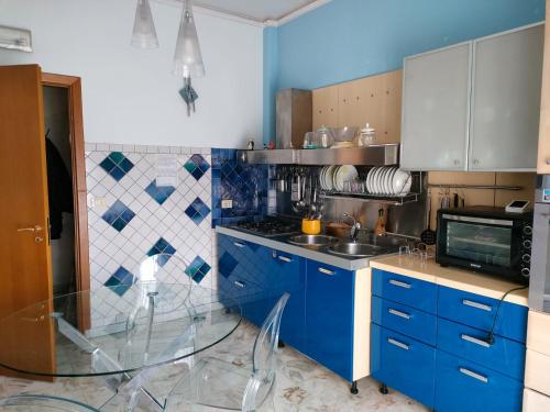 グラヴィーナ・ディ・カターニアにあるSelene Charme and Confortの小さなキッチン(青いキャビネット、シンク付)