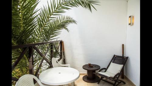 een witte tafel en stoelen in een kamer met een palmboom bij OasisstudioLanzarote in Puerto del Carmen