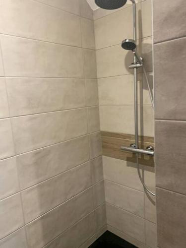 une salle de bain avec une douche avec une porte vitrée dans l'établissement Charmant appartement, aux Angles
