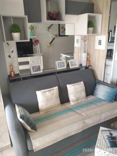 - un canapé dans le salon avec des oreillers dans l'établissement Baie des anges appartement Bis, à Villeneuve-Loubet