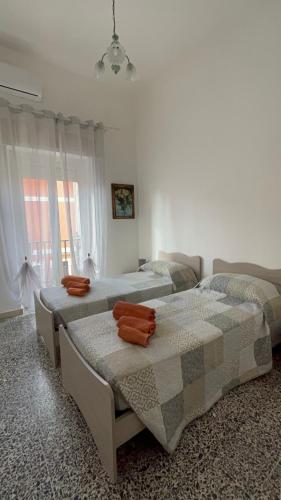 1 dormitorio con 2 camas y ventana en CASA ROSINA, en SantʼAntìoco