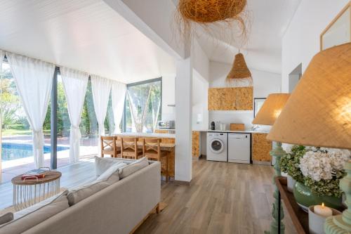 a living room with a couch and a table and a kitchen at Sete Quintas Country House in Salvaterra de Magos