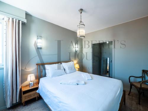 1 dormitorio con 1 cama blanca grande y 1 silla en Porto Ocean View Apartment Foz, en Oporto