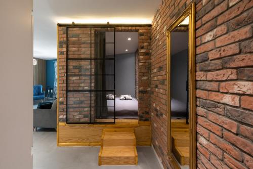 a room with a brick wall and a mirror at Premium Apartment for Jewish Quarter & Old Town plus Pool in Kraków