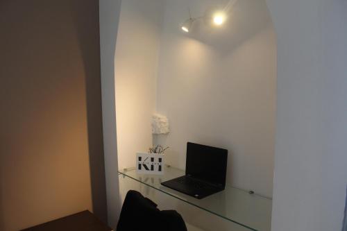 een laptop op een glazen plank in een kamer bij KiMia Home, Centro in Modugno