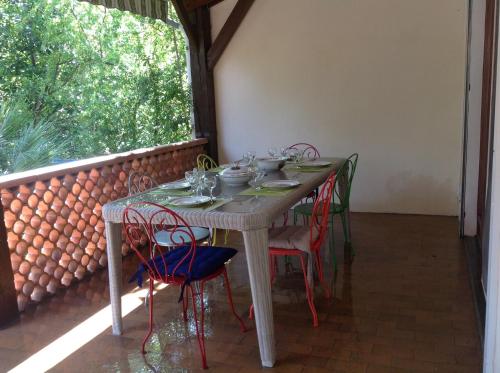 a table with chairs and cups on it on a balcony at La Bigotière avec clim et jardin in Arles