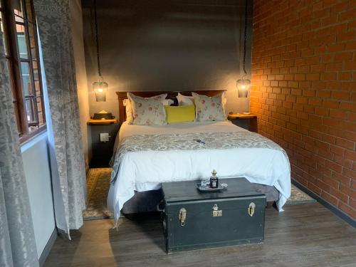 a bedroom with a bed and a brick wall at Greenwood Lea Cottage - luxury, romantic cottage in Hilton
