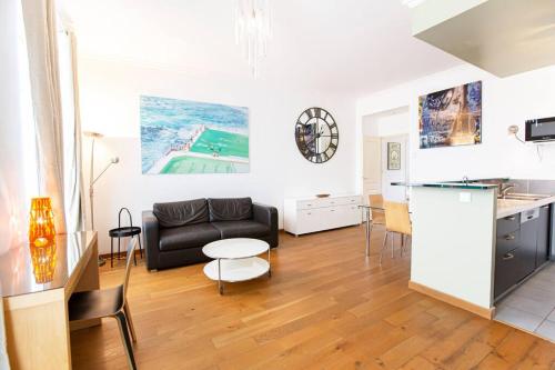 uma sala de estar com um sofá e uma mesa em Proche Panier, appartement cosy vue mer em Marselha