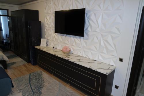 a living room with a tv on a wall at Apartment ǨS Brasov in Braşov