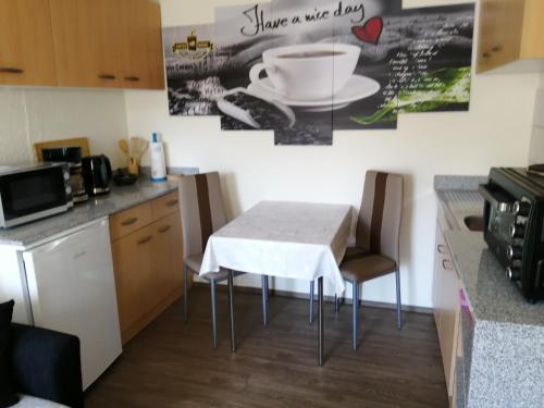 Il comprend une petite cuisine avec une table et des chaises blanches. dans l'établissement Ferienwohnung auf Rügen, à Putbus