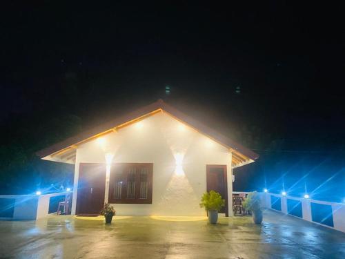 een wit gebouw met 's nachts verlichting bij White Eco Villa in Kandy