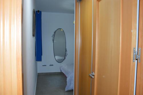 a hallway with a mirror and a room with a bed at Centro in Málaga