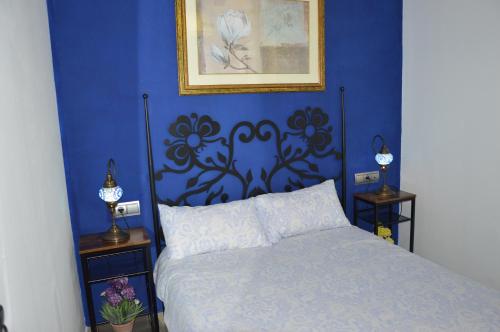 a bedroom with a bed with a blue wall at Centro in Málaga