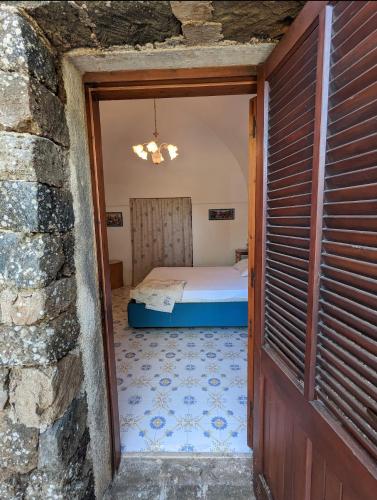 a door to a bedroom with a bed in a room at Dammuso i Pini di Kaddiuggia (CIR19081014C224053) & Dammuso di Mena (CIR 19081014C224052 in Pantelleria