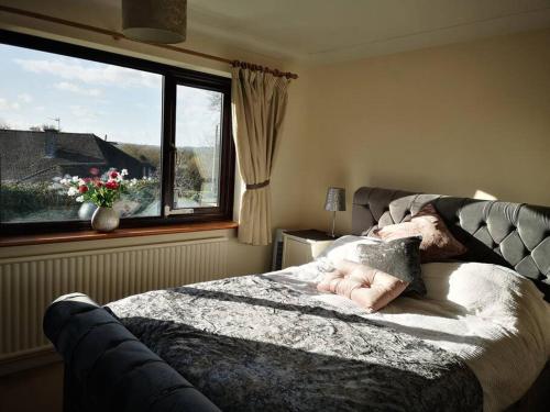 eine Person, die in einem Schlafzimmer mit Fenster auf einem Bett liegt in der Unterkunft Large 4 double bed house 20 mins from Bath City in Bristol