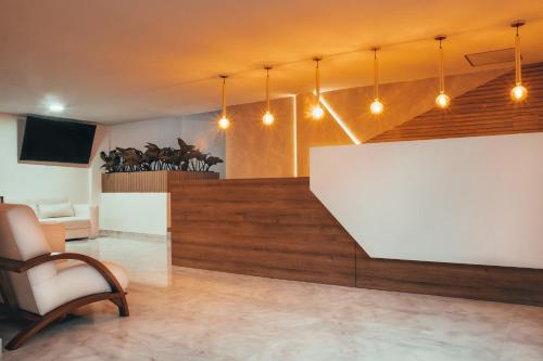 a lobby with a white table and a chair at Hotel Gran Plaza San Agustin in San Agustín