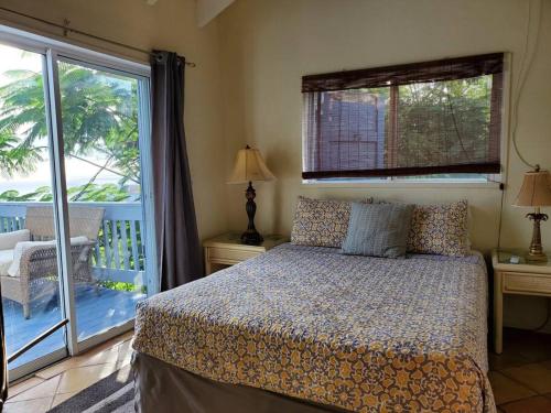 una camera con letto e balcone di The Cottage at Villa Indigo a Charlotte Amalie