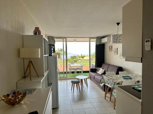 una cucina e un soggiorno con divano e tavolo di Vue mer et sur la baie de Cannes piscine 450m2 randonnée VTT au pied de l Esterel a Théoule-sur-Mer