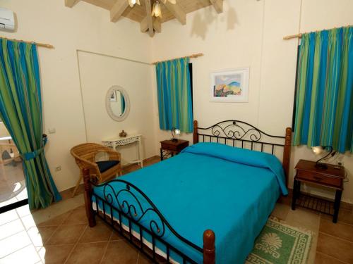 a bedroom with a blue bed and blue curtains at Dafni (2 bedrooms, sleeps 4) in Sami