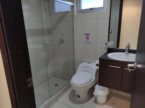 een badkamer met een douche, een toilet en een wastafel bij Suite Ejecutiva en excelente ubicación con Piscina-Parqueo-Gym-Seguridad 24/7 in Guayaquil