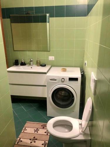 a bathroom with a toilet and a sink and a washing machine at Intero appartamento Milano in Bollate