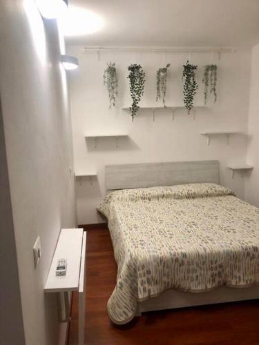 1 dormitorio con 1 cama y una pared blanca con plantas en Intero appartamento Milano, en Bollate