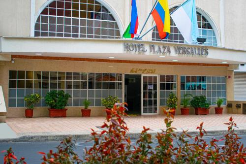 un hotel con banderas frente a un edificio en Hotel Plaza Versalles, en Cali