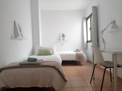 a bedroom with a bed and a table and a desk at Casa Calderetas in San Bartolomé