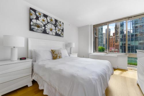a white bedroom with a white bed and a window at Global Luxury Suites at The Marc in New York