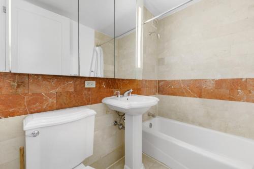 a bathroom with a sink and a toilet and a tub at Global Luxury Suites at The Marc in New York