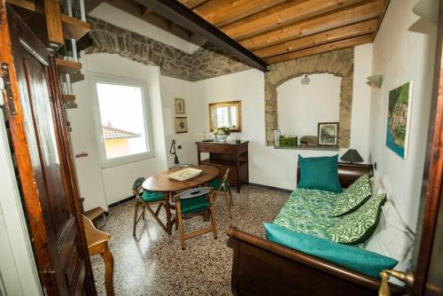 uma sala de estar com uma mesa e um sofá em CodeminCampiglia Casa Vista Mare con Giardino em Campiglia
