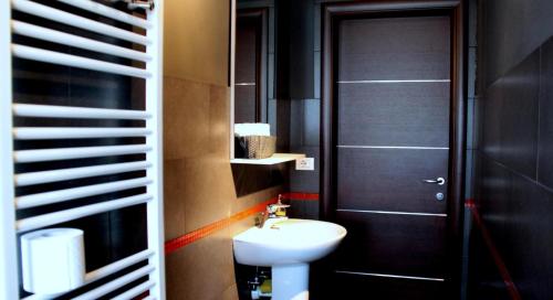 トリノにあるSan Donato Apartmentsのバスルーム(黒いドア、白いシンク付)