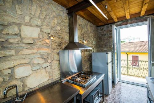 uma cozinha com um fogão e uma parede de pedra em CodeminCampiglia Casa Vista Mare con Giardino em Campiglia