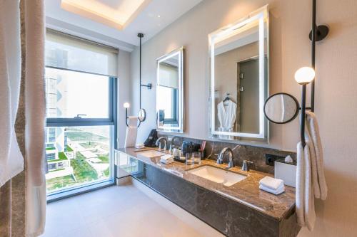 ein Badezimmer mit zwei Waschbecken und einem großen Fenster in der Unterkunft Savitsky Plaza in Samarkand