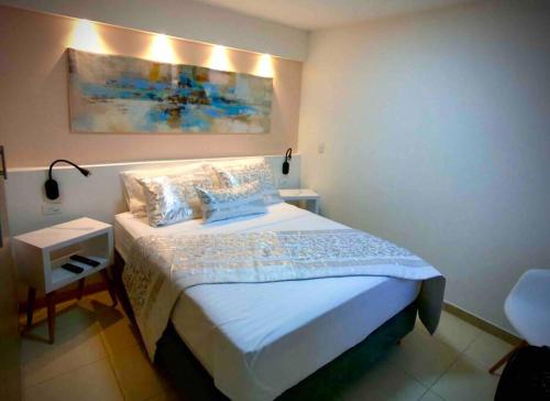 a bedroom with a bed and a painting on the wall at Descanso y confort 2 in La Tebaida