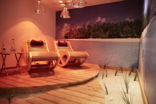 two chairs on a wooden deck with a painting on the wall at Aparthotel Bernstein in Büsum