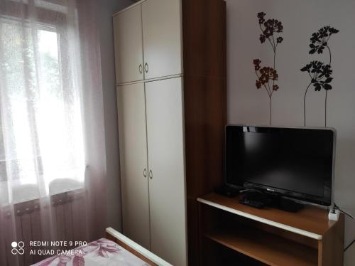 un soggiorno con TV e armadietti bianchi di Apartment Tominovic a Opatija