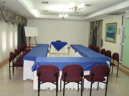 a conference room with blue tables and red chairs at Hotel Plaza Versalles in Cali